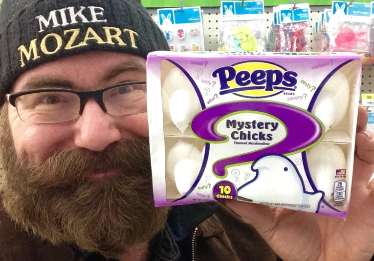 a man in a hat holding up a piece of peeps mystery chicks