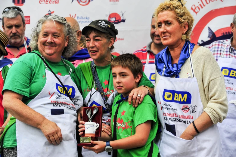 three women and two boys holding an award