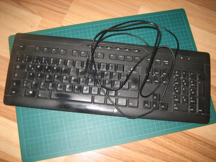 a keyboard and a black cord attached to it