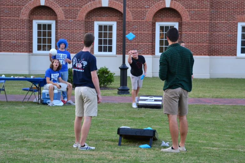 some people playing cornhole game at an outside event