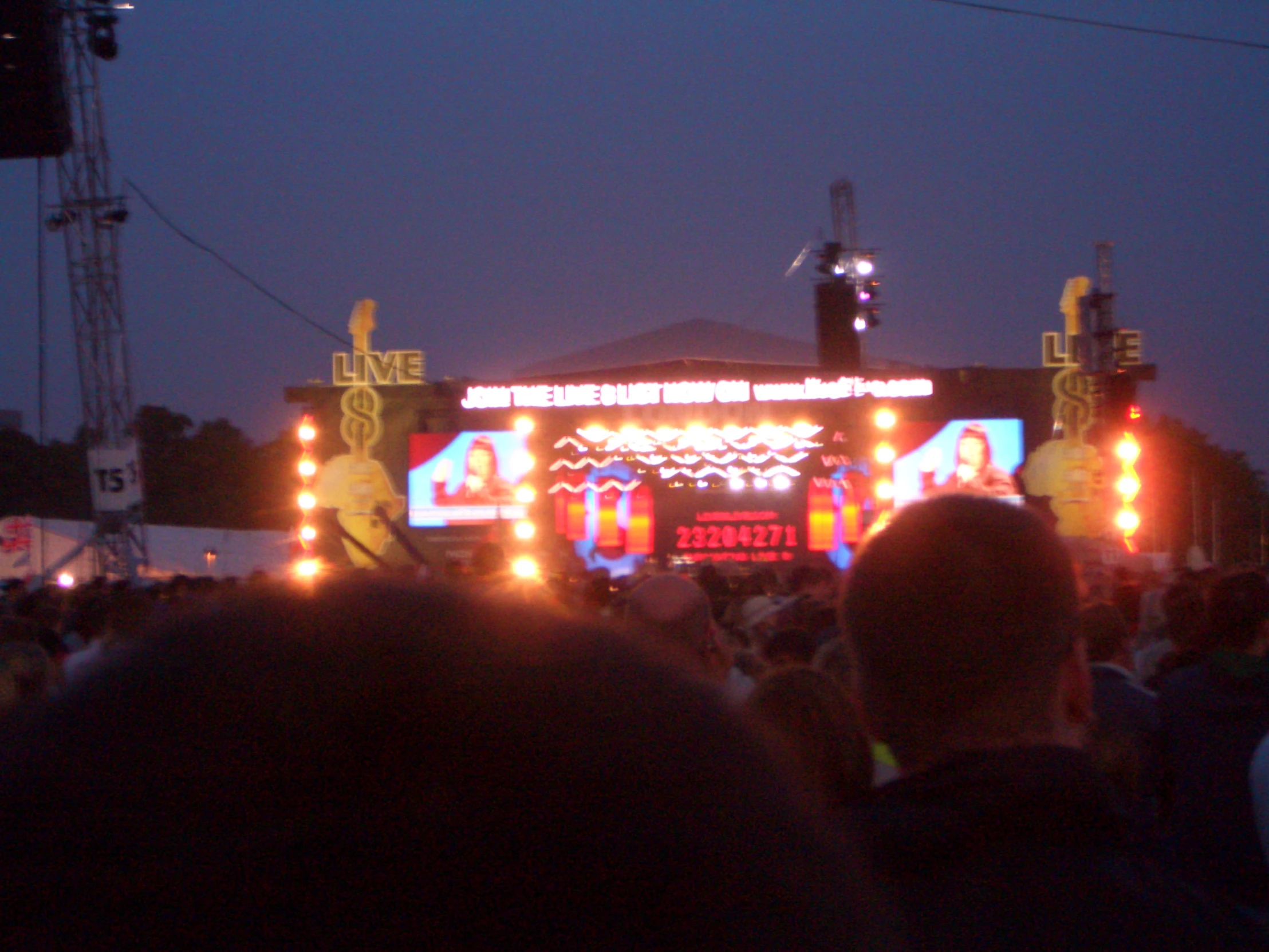 a concert stage lit up at night time with many people