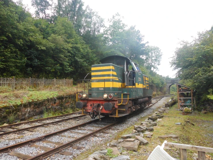 a train is coming down the tracks by some trees