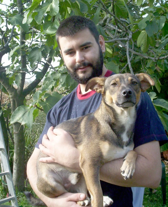 a man holding a dog in his right arm