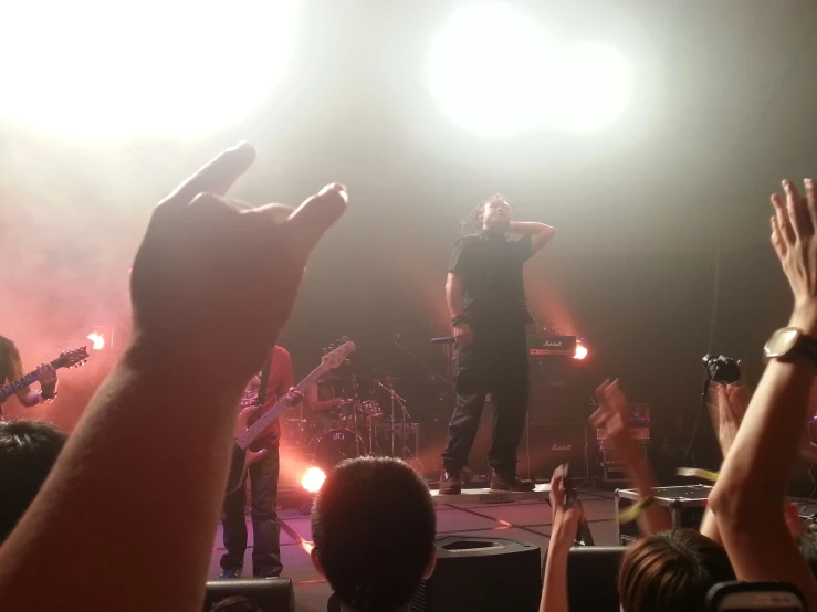 a group of people standing on top of a stage holding up their hands