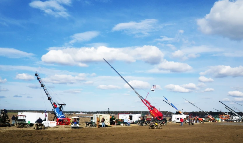 many cranes are on the ground near an airfield