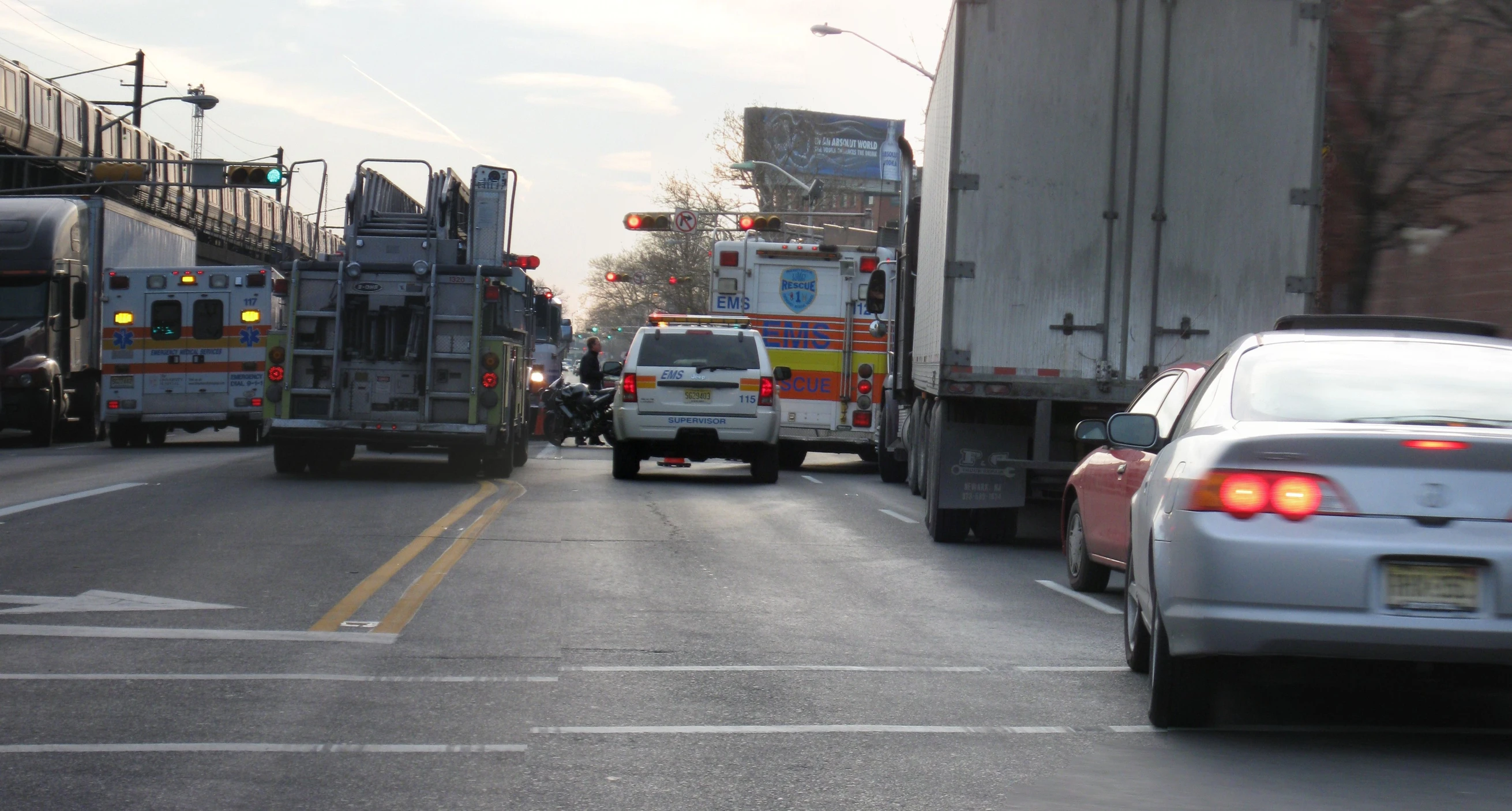 cars in front of firetrucks with an onlooker