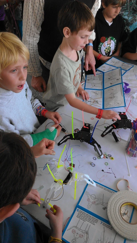 the children are working on paper at a table