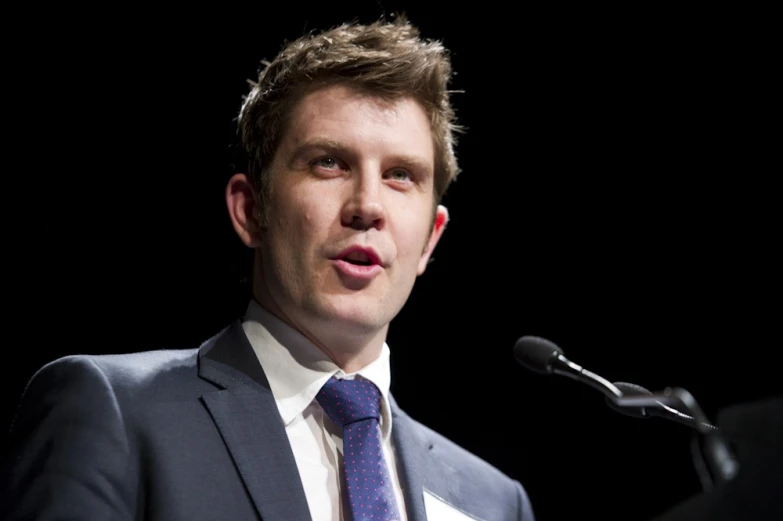 a man with his eyes closed and speaking into a microphone