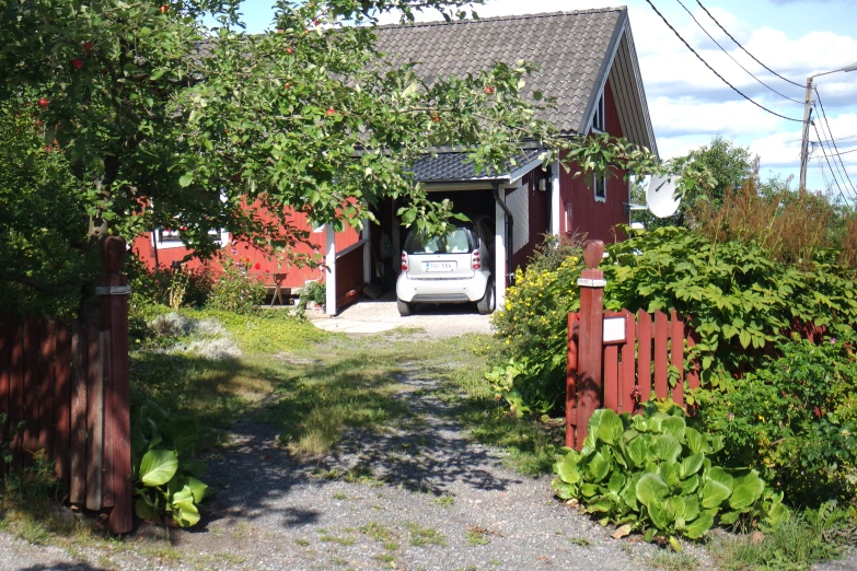 there is a car entering an entrance to a small red house