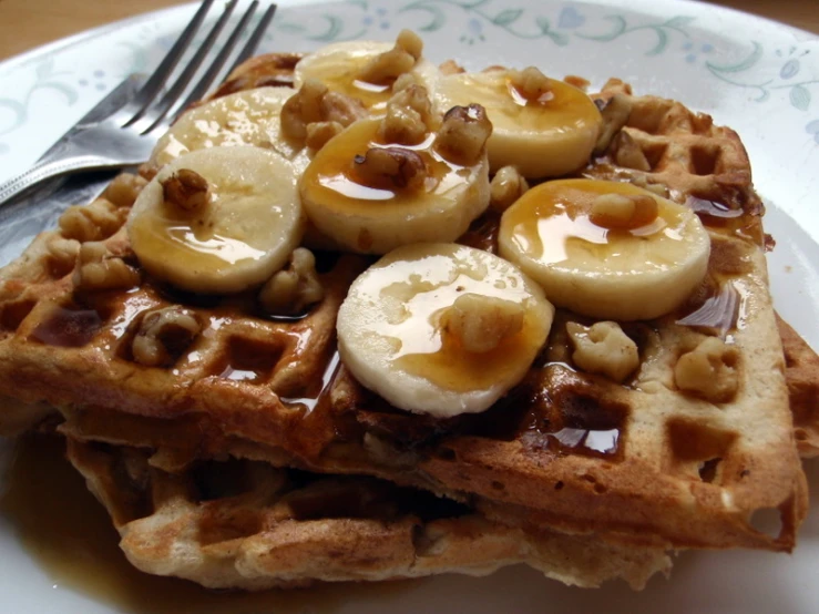 there is a waffle with bananas on top and nuts