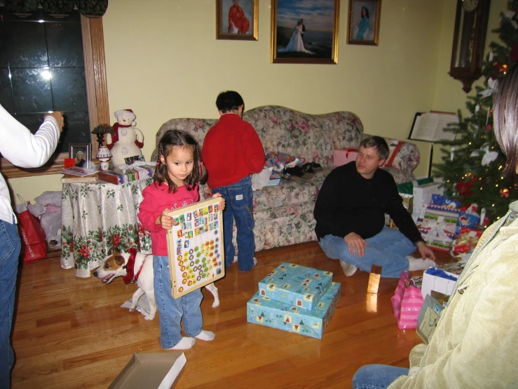 a group of people holding christmas presents in the living room