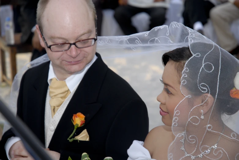 a bride and groom looking at their cell phone