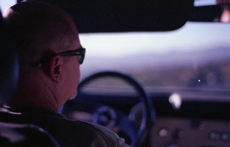 a man drives his car during the evening