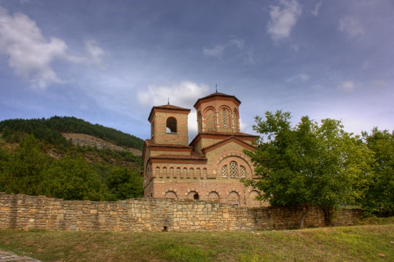 a tall building with two towers sitting next to a field