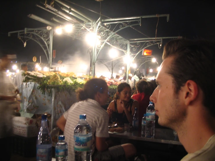 people sit in the rain eating food outside at night