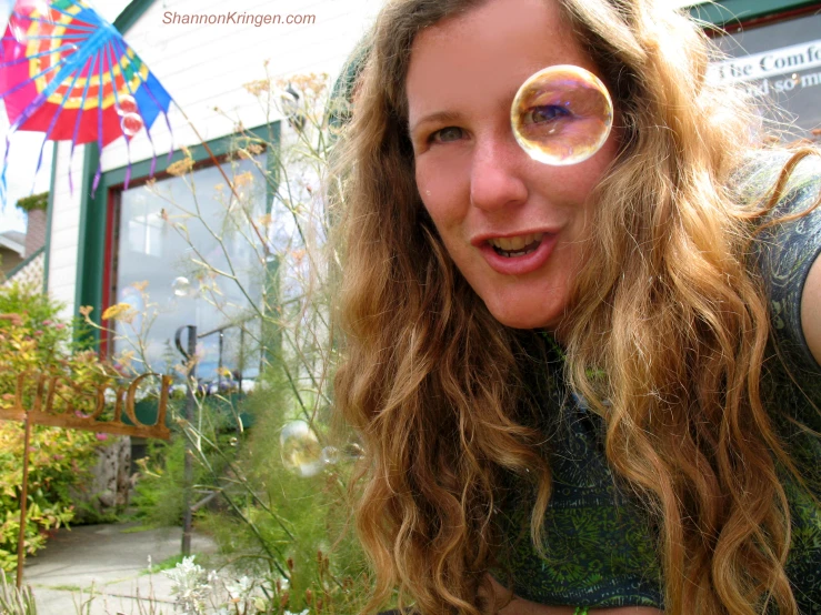 woman blowing bubbles by her house on a  summer day