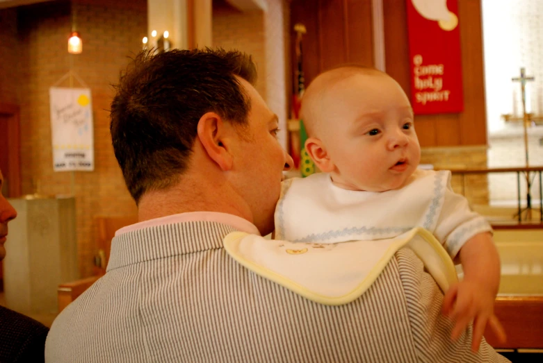 a man holding a baby and pointing at it