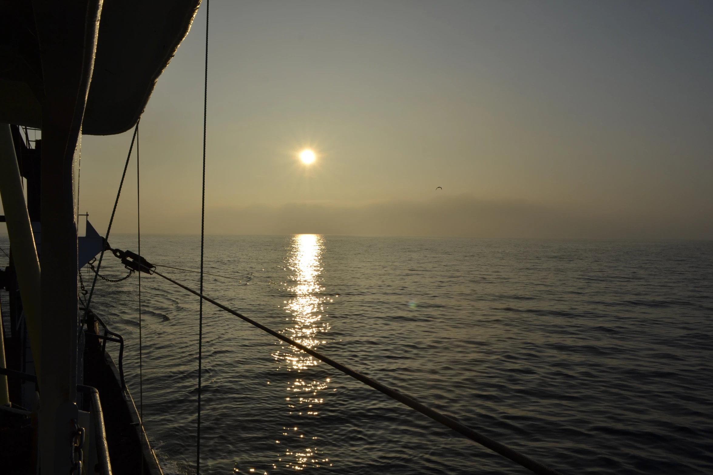 a sailboat with the sun behind it