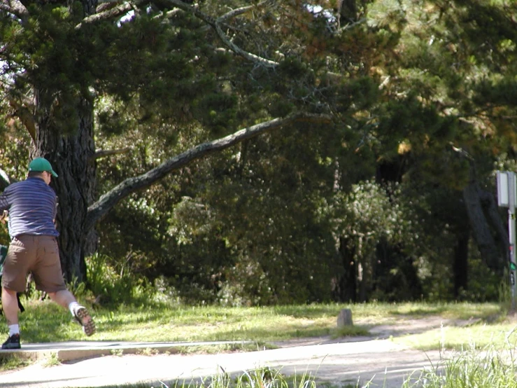 the man is walking down the path with his skateboard