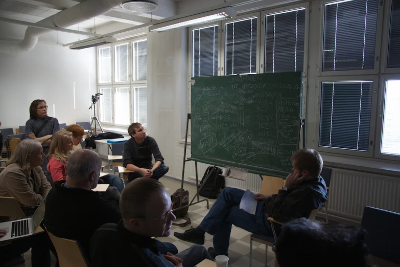 several people sitting around each other in a classroom