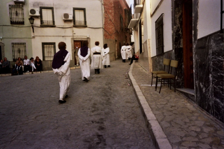 some people walking down the street near some buildings