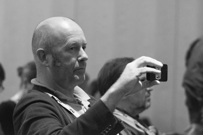 a black and white pograph of a man holding a camera