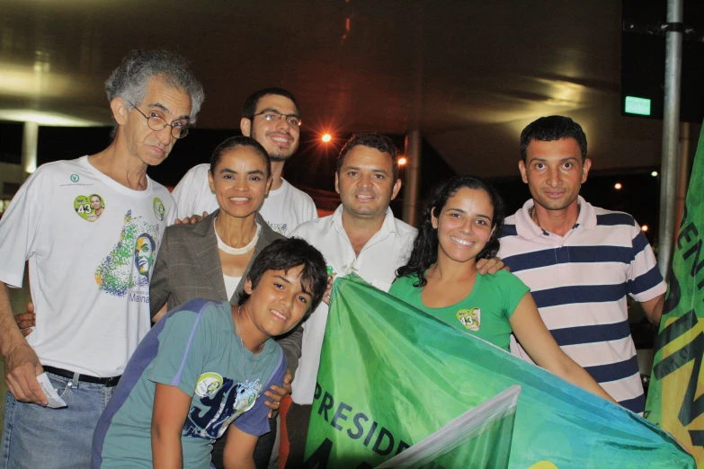 several people holding a green and white flag