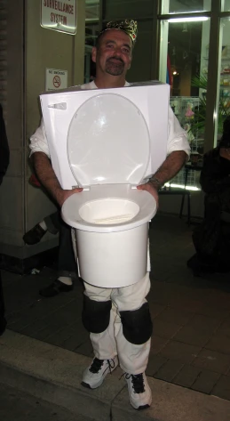 a man dressed as a soccer referee holding a toilet