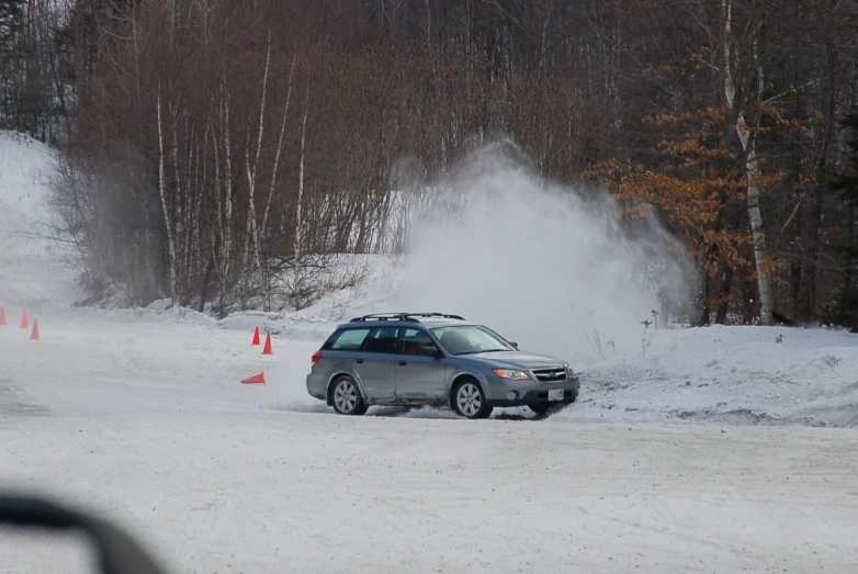 an suv drives through a ski area next to cones
