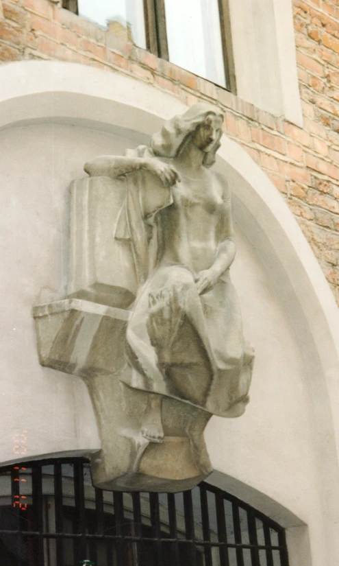 a statue on the side of a building with a window