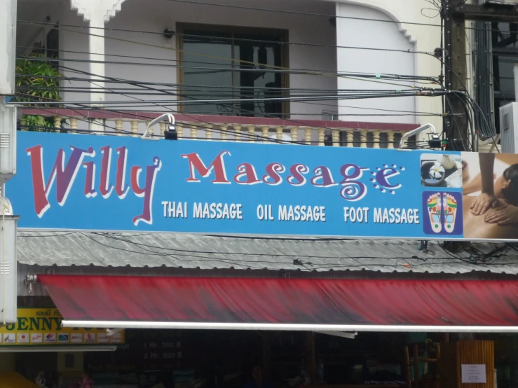 a blue sign hangs above a massage shop