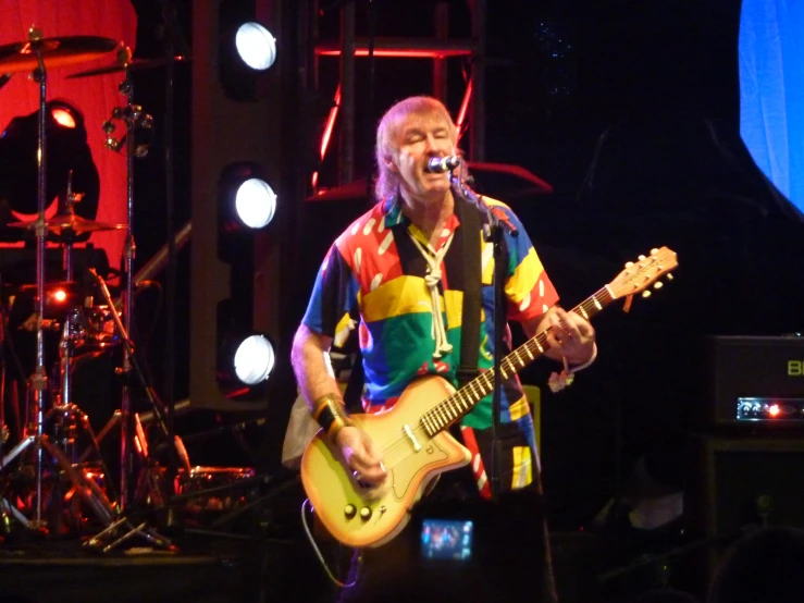 a man on stage playing an electric guitar