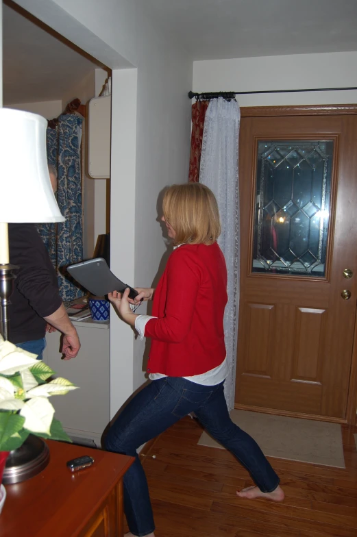 woman on a laptop in the living room with man nearby