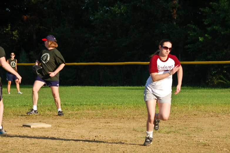 a couple of s playing baseball in a field