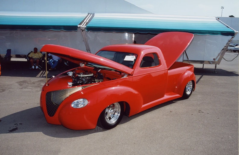 a classic truck with its hood open at an auto show