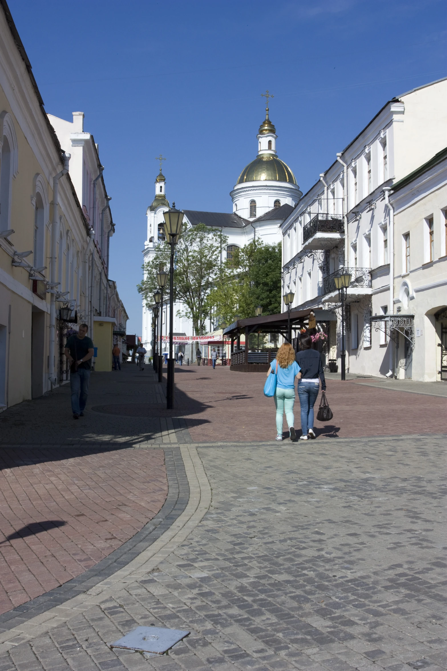 some people are walking around town and there are buildings