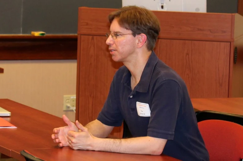 a man sitting at a desk with an object in front of him