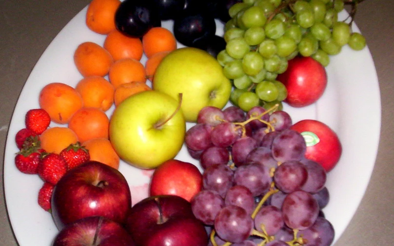 a plate full of different kinds of fruit on top of a table