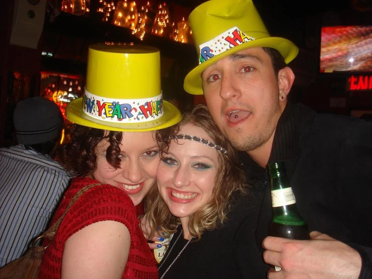 three people posing for a po together with a bottle