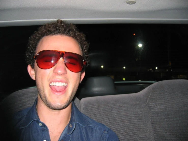 man sitting in the back seat of a car wearing sunglasses