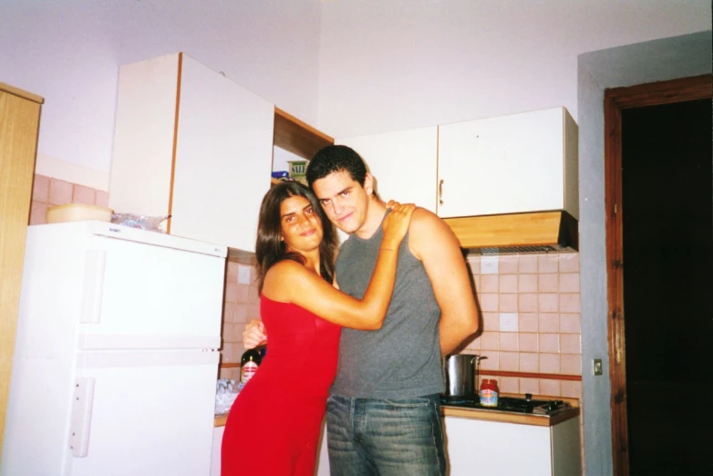 a man and woman posing for a picture in a kitchen