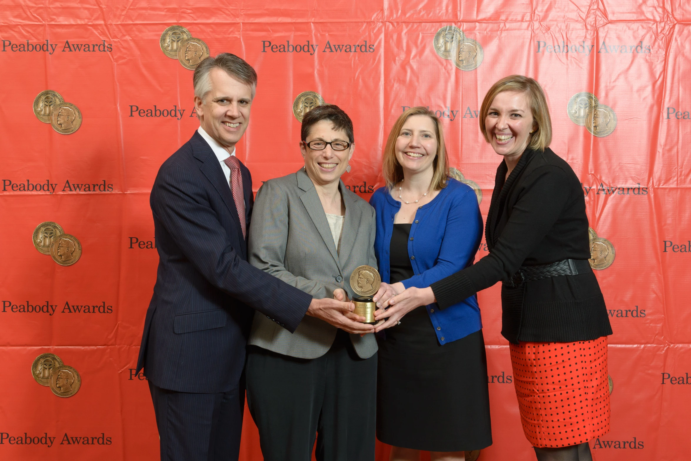 a man standing next to three women at an event