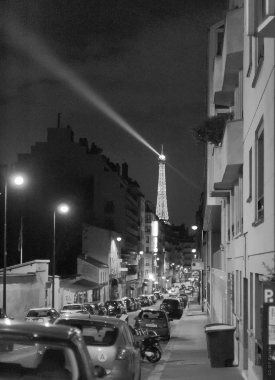 a black and white po shows parked cars, cars and a eiffel tower