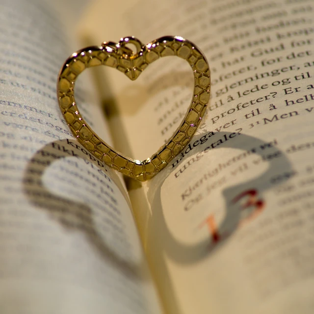 a heart shaped object standing on top of a book