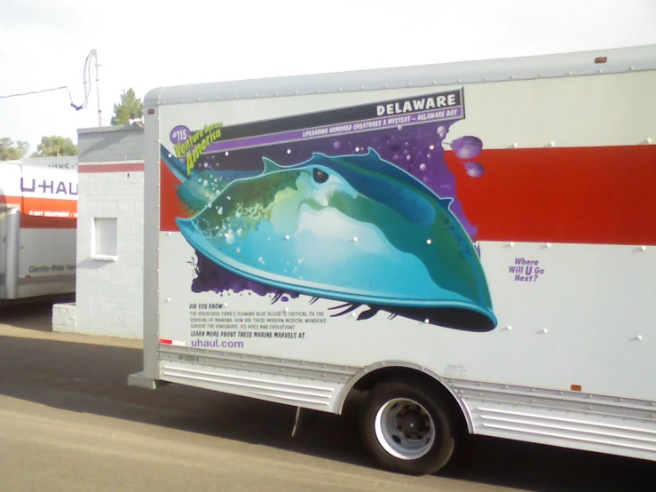 the box truck is white and red with a whale on it