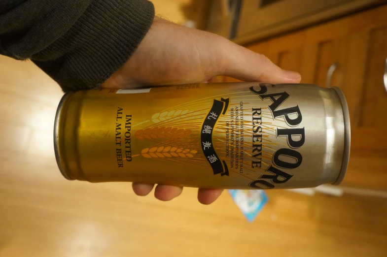 someone holding up a can of saporo imperial beer