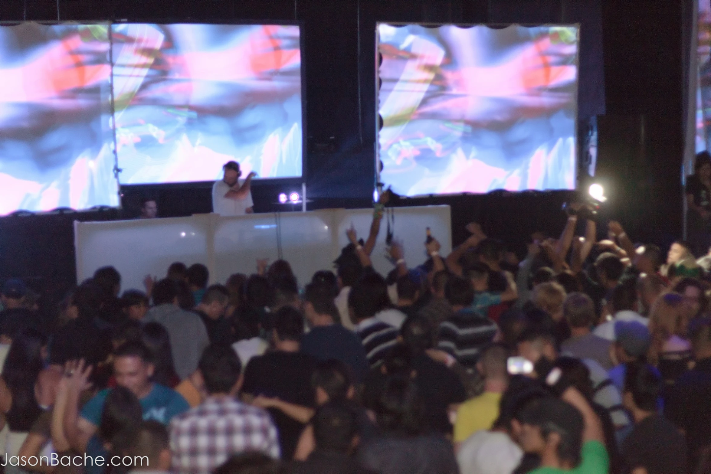 people standing in front of large screens at a show