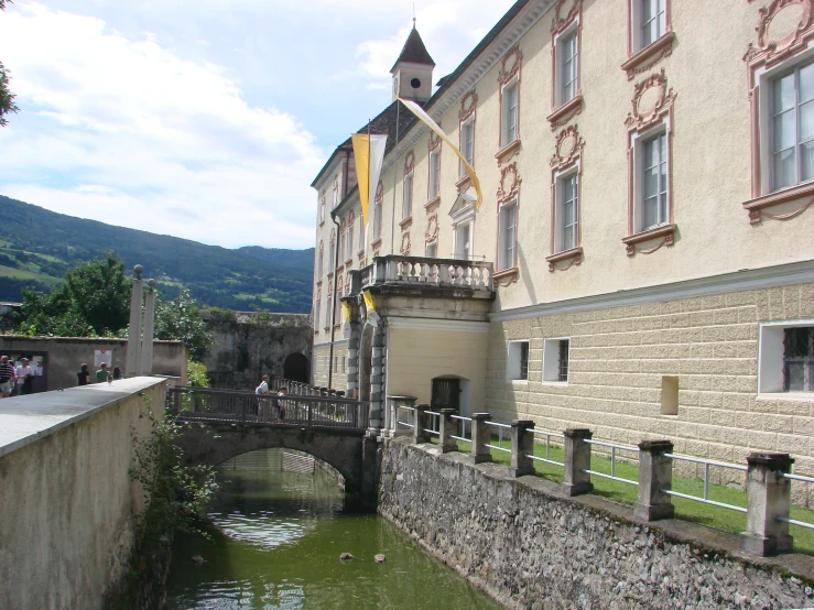 a bridge over a small river near a building