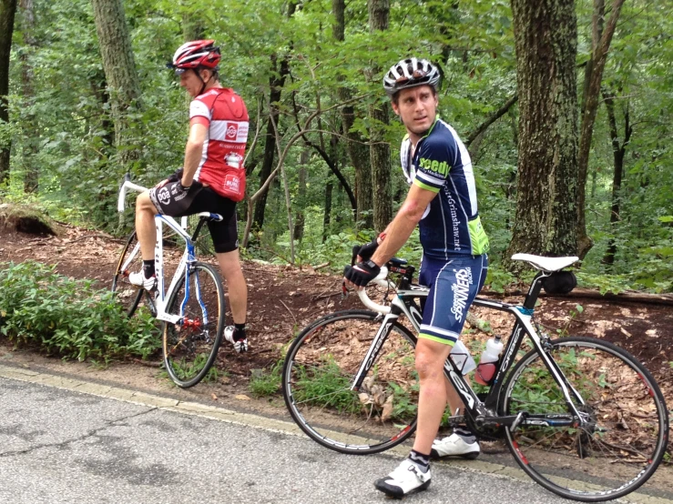 two young men riding bicycles down the street