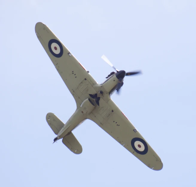 a small airplane flying in the sky with a propeller